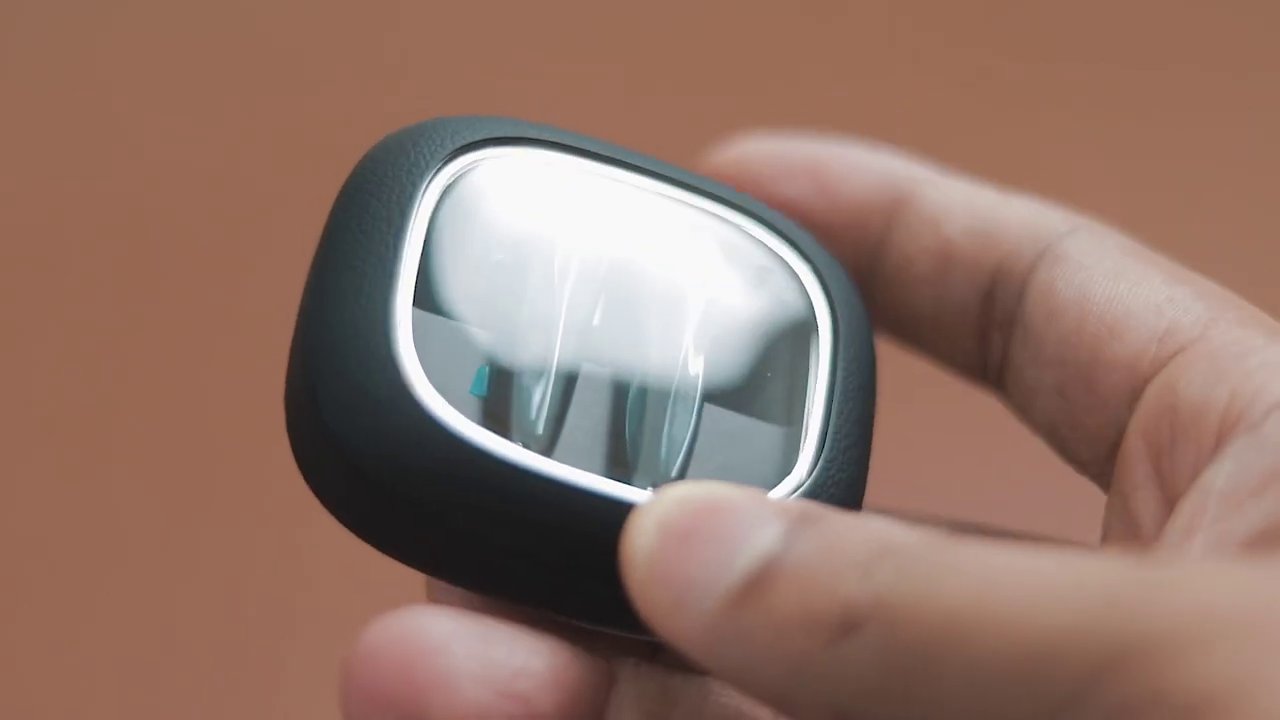 A close-up shot of the earbuds' charging case, emphasizing the textured leather finish and compact form factor.