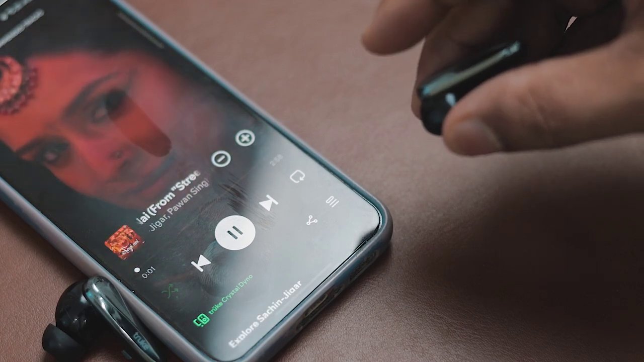The reviewer demonstrates the touch controls on the earbuds, likely showing the LED lights in action.