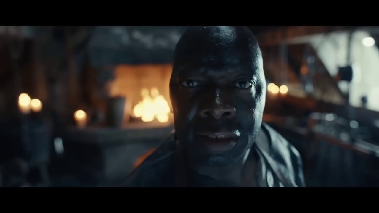 A Diablo 4 character standing in a dark dungeon, surrounded by loot drops on the ground.